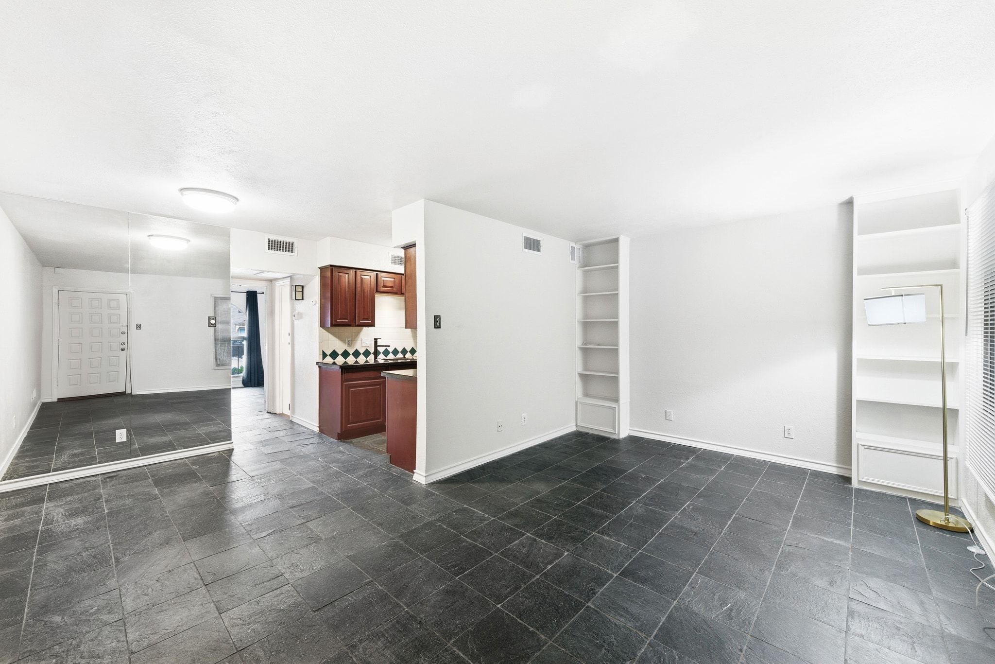 505 West 7th Street, Unit 106 Austin, TX 78701 - Photo 2 of 21 Unfurnished living room with baseboards and dark stone finish floors