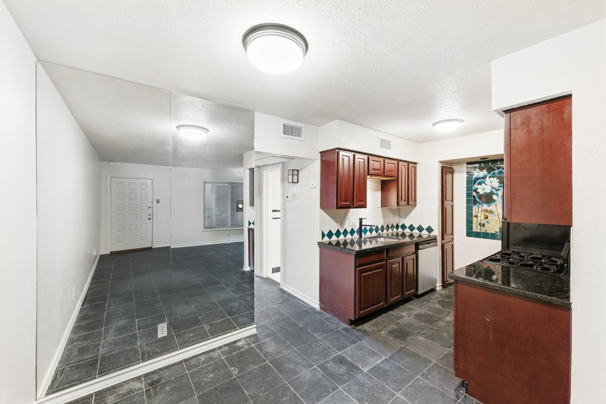 505 West 7th Street, Unit 106 Austin, TX 78701 - Photo 7 of 21 Kitchen with dark countertops, dishwasher, black gas stovetop, and backsplash