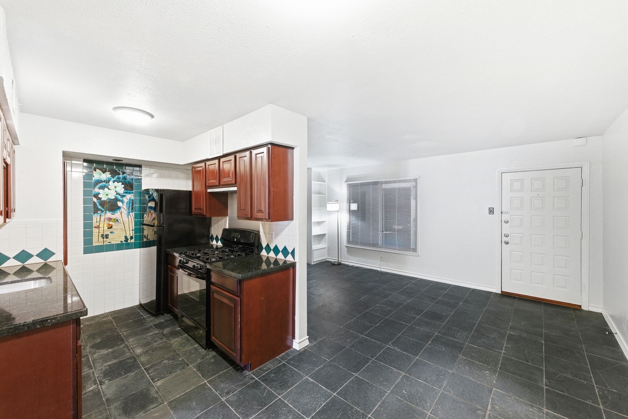 505 West 7th Street, Unit 106 Austin, TX 78701 - Photo 8 of 21 Kitchen featuring black appliances and dark stone countertops
