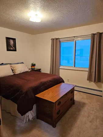 a bedroom with a bed and painting on the wall