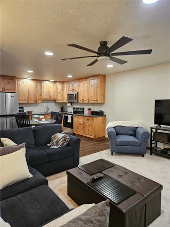 a living room with furniture and a view of kitchen