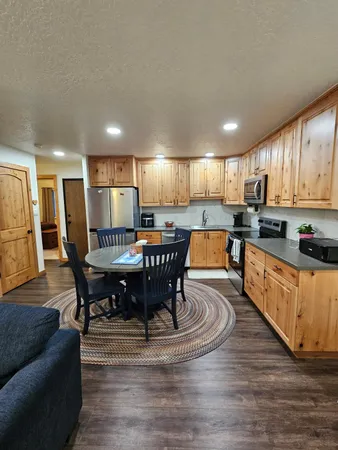 a kitchen with a dining table chairs and refrigerator