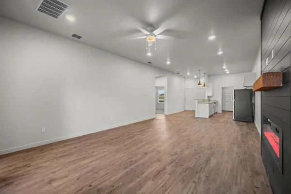 a view of kitchen and a hallway with wooden floor