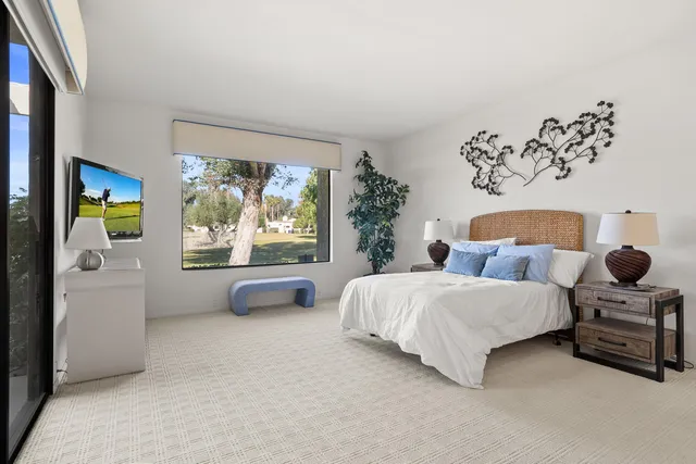 a bedroom with a bed and a large window