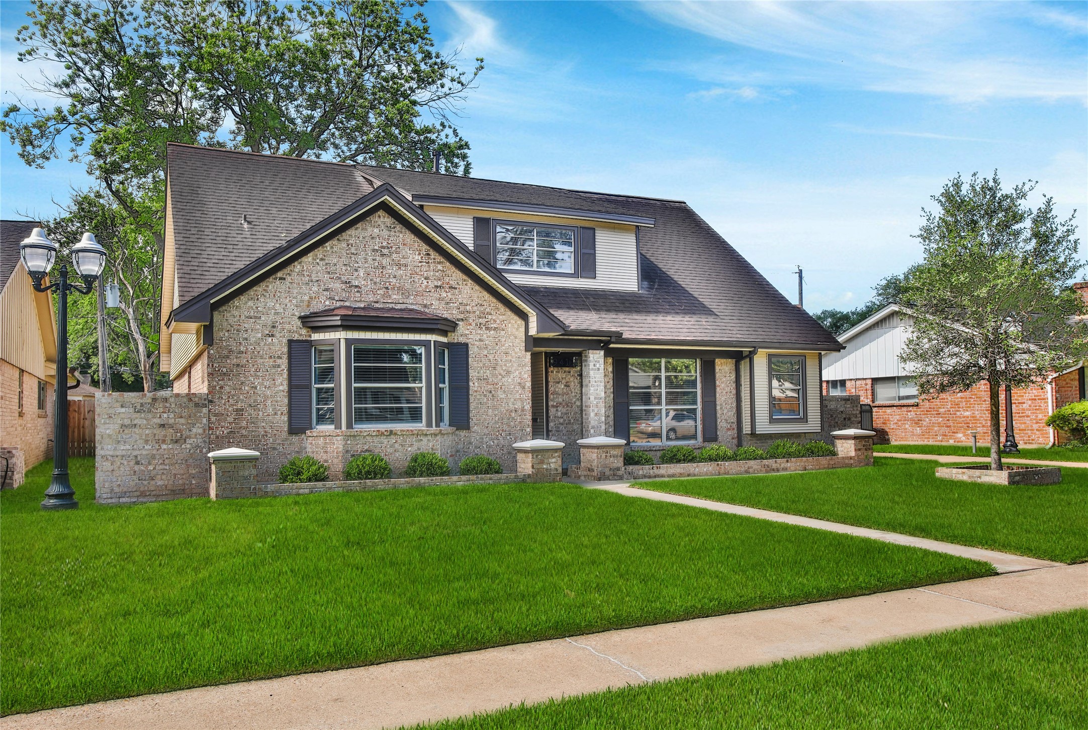 a front view of a house with a yard and trees