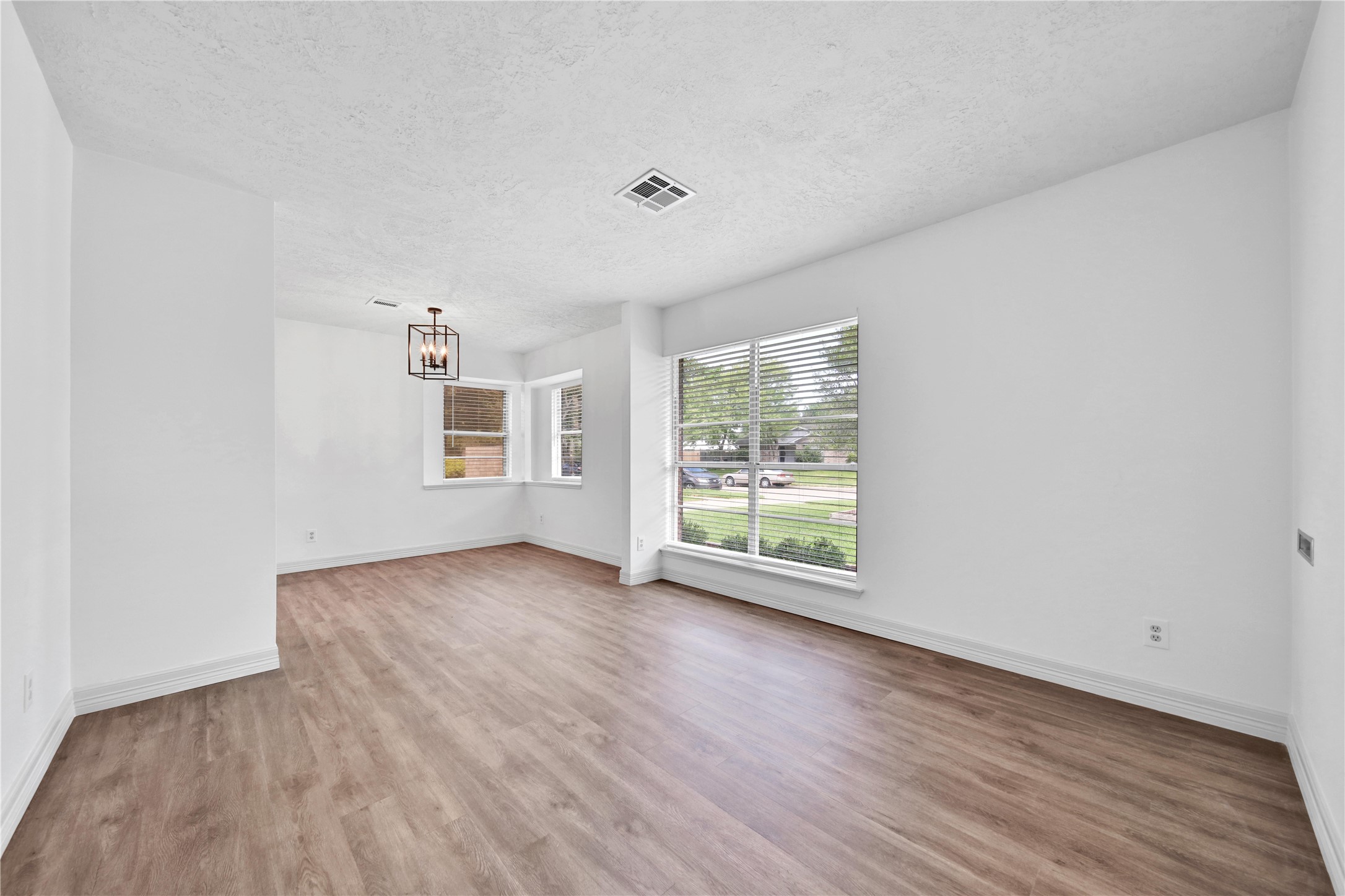 9411 Roos Road Houston, TX 77036 - Photo 10 of 41 an empty room with wooden floor and windows