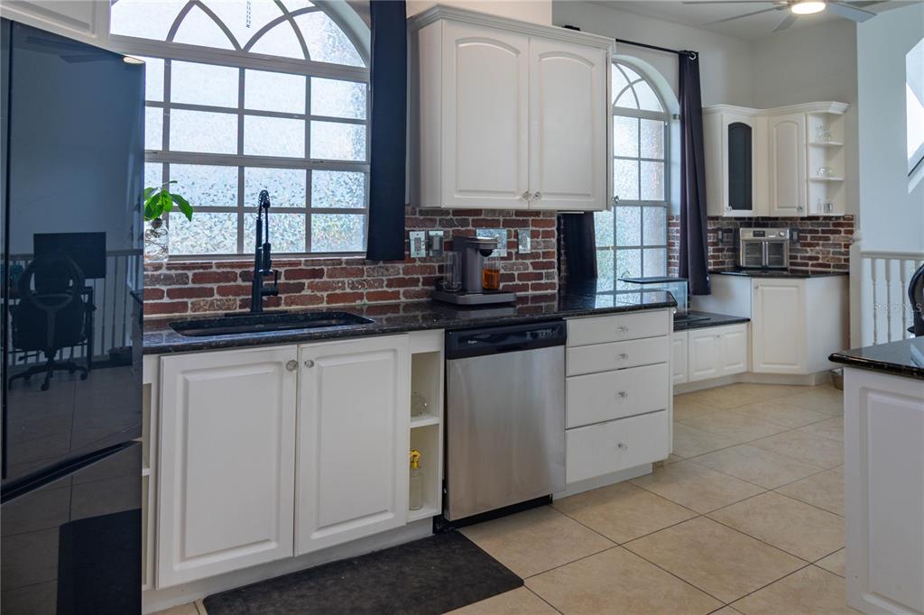 6151 New Osprey Point Weeki Wachee, FL 34607 - Photo 27 of 63 a kitchen with stainless steel appliances a sink window and cabinets