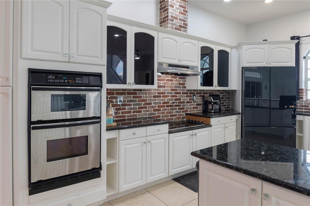 6151 New Osprey Point Weeki Wachee, FL 34607 - Photo 31 of 63 a kitchen with granite countertop white cabinets stainless steel appliances and sink