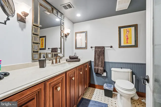 a bathroom with a sink a toilet and mirror
