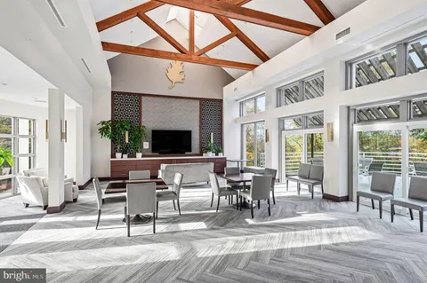 a living room with furniture a flat screen tv and a floor to ceiling window