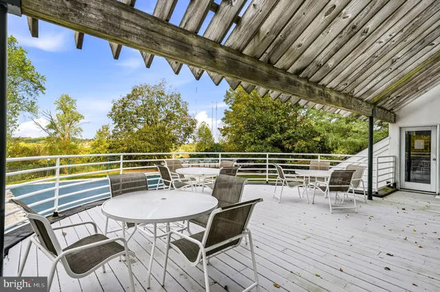 a view of a chairs and table on the wooden roof deck
