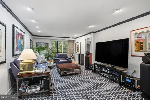 a living room with furniture a flat screen tv and a floor to ceiling window