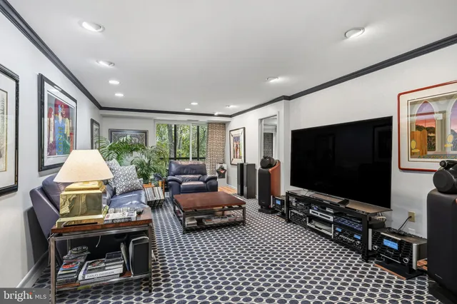 a living room with furniture a flat screen tv and a floor to ceiling window