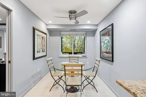 a dining room with chandelier fan and wooden floor