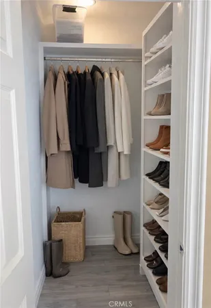 a view of walk in closet with clothes and shoes