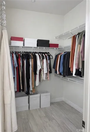 a view of walk in closet with clothes and shoes