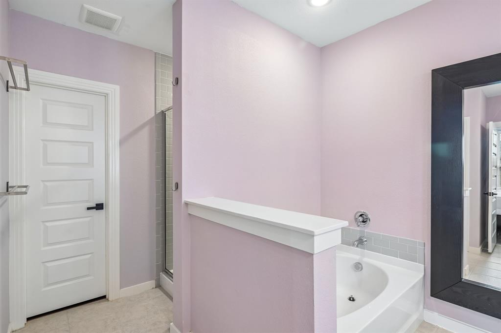 1805 Huntsman Way Forney, TX 75126 - Photo 26 of 34 Bathroom featuring a built-in soaking tub with subway tile surround, glass-enclosed shower, and a full-length mirror