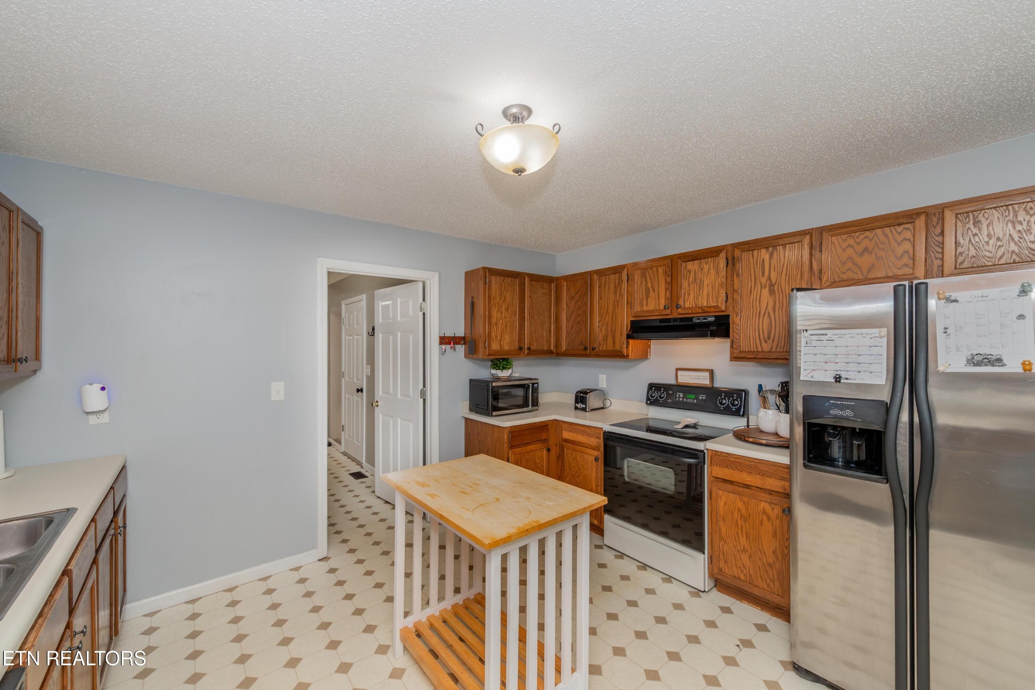 3919 Morganton Road Maryville, TN 37801 - Photo 14 of 29 a kitchen with stainless steel appliances granite countertop a stove top oven a refrigerator a sink a dining table and chairs