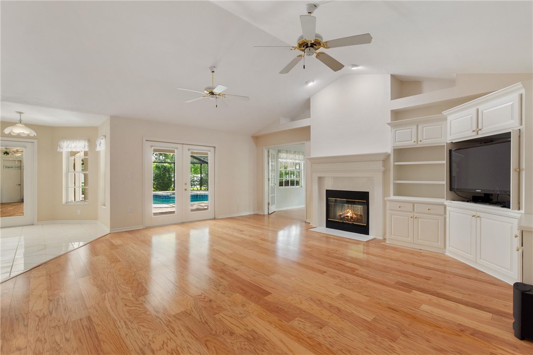 5521 Emerald Ridge Boulevard Lakeland, FL 33813 - Photo 13 of 33 a view of a livingroom with a fireplace a ceiling fan and wooden floor