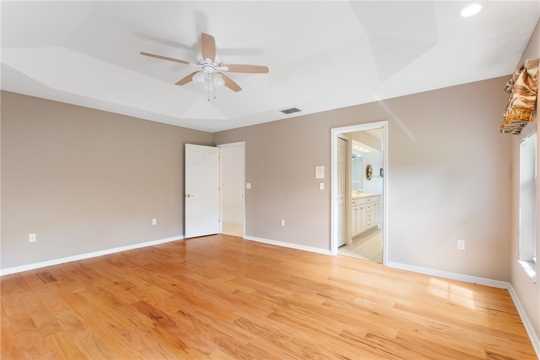 5521 Emerald Ridge Boulevard Lakeland, FL 33813 - Photo 17 of 33 a view of an empty room with wooden floor and a ceiling fan