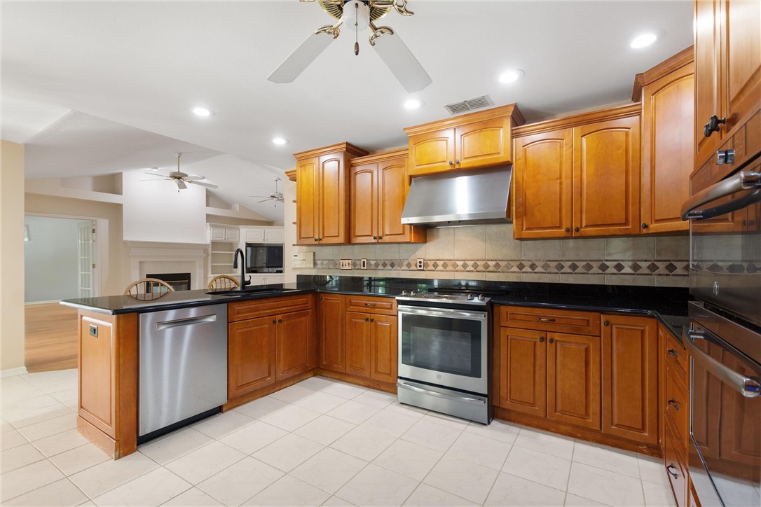 5521 Emerald Ridge Boulevard Lakeland, FL 33813 - Photo 8 of 33 a kitchen with stainless steel appliances granite countertop a stove sink and cabinets