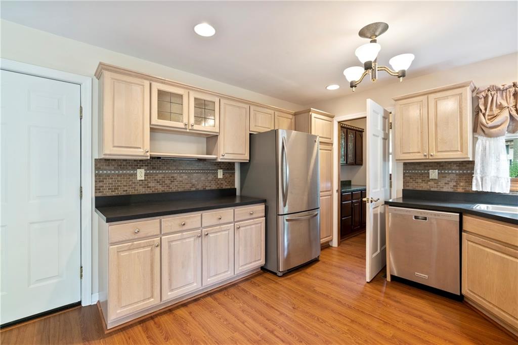 138 Valley Road Eighty Four, PA 15330 - Photo 12 of 33 a kitchen with granite countertop a refrigerator a stove a sink cabinets and wooden floor