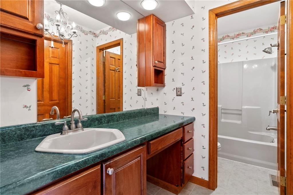 138 Valley Road Eighty Four, PA 15330 - Photo 18 of 33 a bathroom with a granite countertop sink a mirror a shower and a bathtub