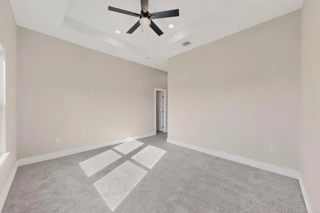 an empty room with a ceiling fan and window