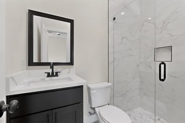 a bathroom with a toilet sink shower and mirror