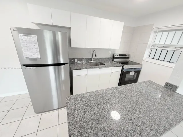 a kitchen with kitchen island granite countertop a sink and a stove
