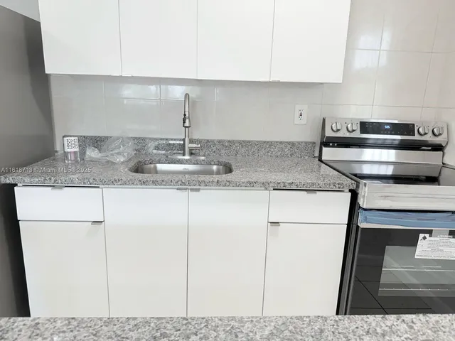 a kitchen with stainless steel appliances granite countertop a refrigerator sink and stove