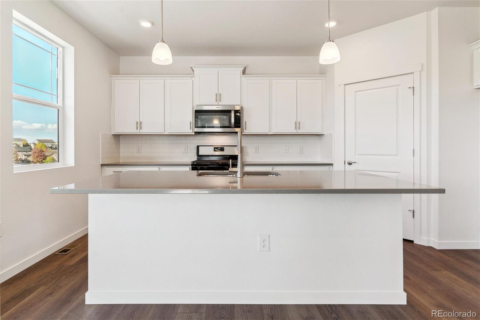 2220 Base Street Fort Lupton, CO 80621 - Photo 10 of 36 a kitchen with stainless steel appliances a microwave a sink and cabinets