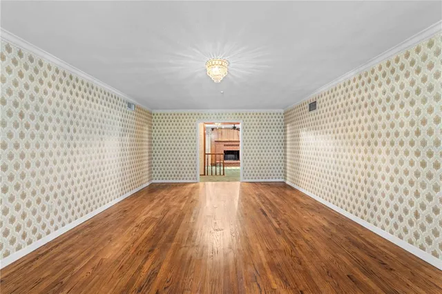 a view of an empty room with fireplace and a window