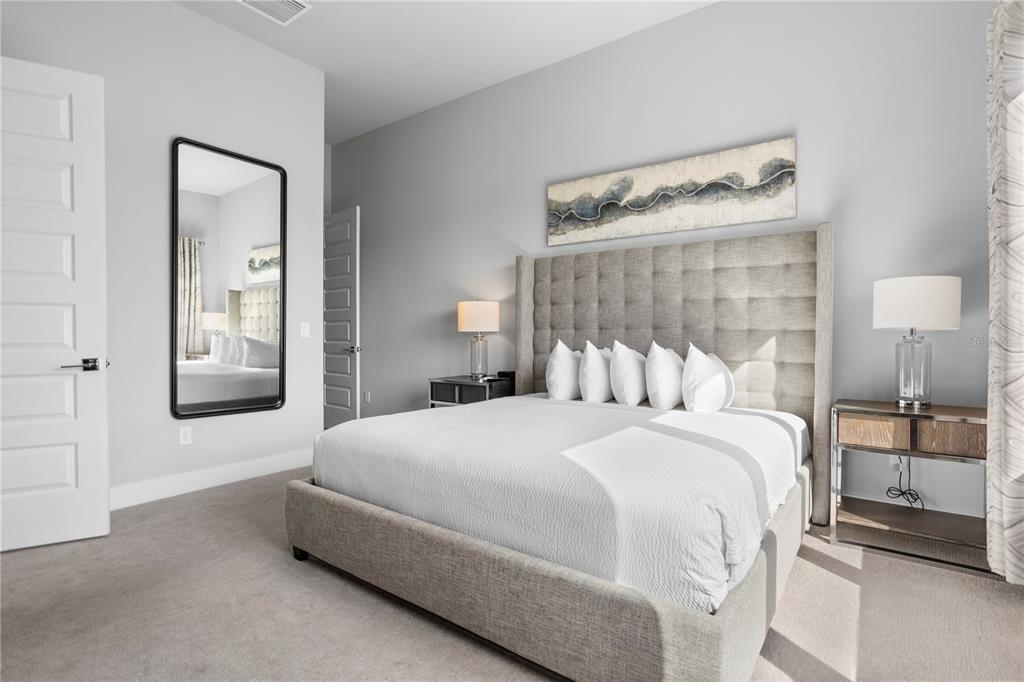 7770 Sandy Ridge Drive, Unit 207 Reunion, FL 34747 - Photo 18 of 61 a bedroom with a bed and a mirror