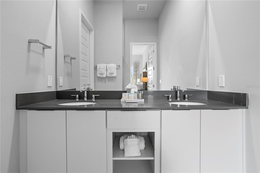 7770 Sandy Ridge Drive, Unit 207 Reunion, FL 34747 - Photo 20 of 61 a bathroom with double sink and a mirror