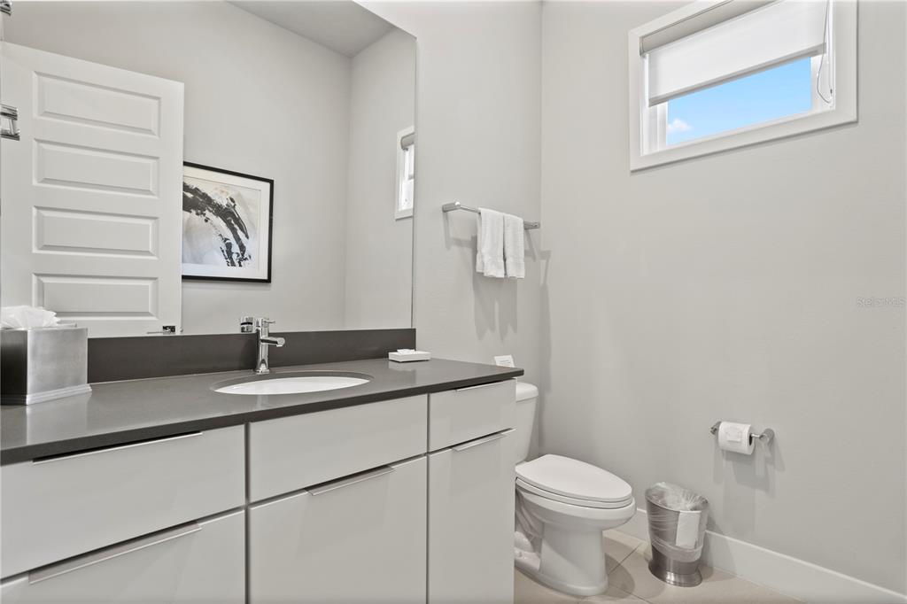 7770 Sandy Ridge Drive, Unit 207 Reunion, FL 34747 - Photo 26 of 61 a bathroom with a granite countertop toilet sink and mirror