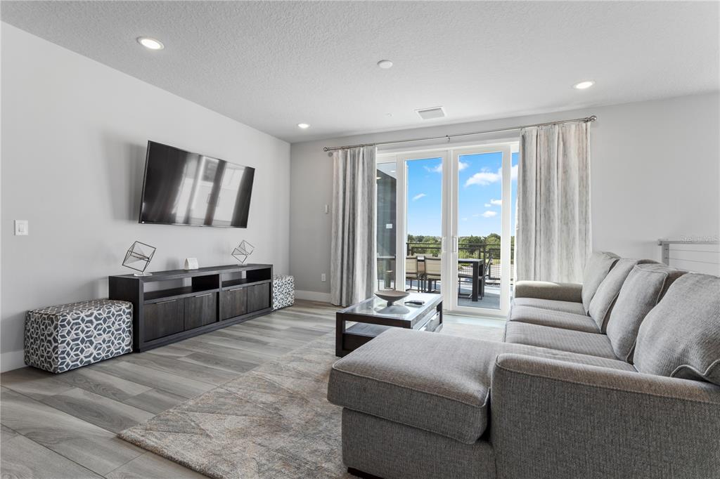 7770 Sandy Ridge Drive, Unit 207 Reunion, FL 34747 - Photo 33 of 61 a living room with furniture and a flat screen tv