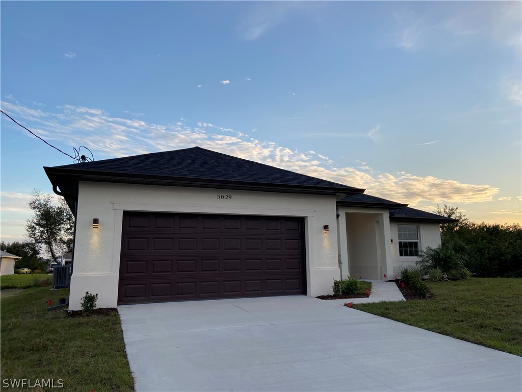 a front view of a house with a yard and garage