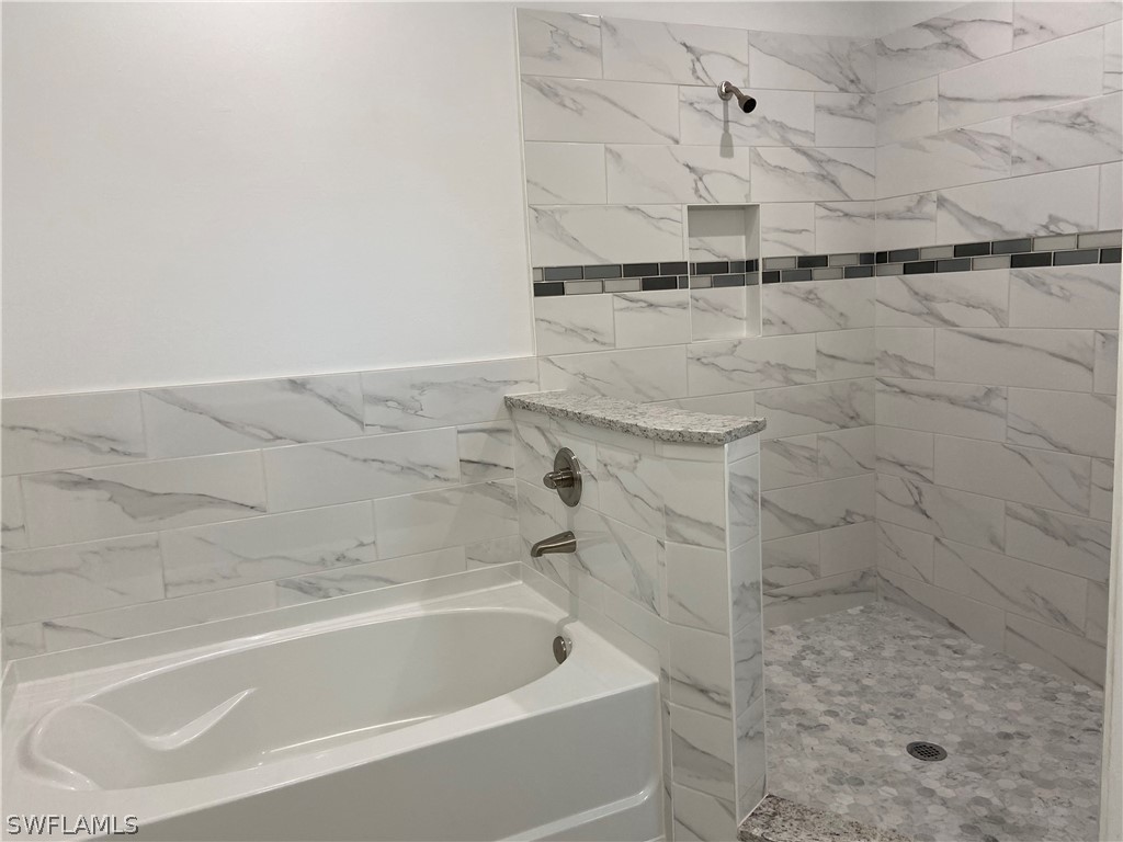 5029 Bristo Street Lehigh Acres, FL 33971 - Photo 13 of 14 a bathroom with a shower and a bathtub