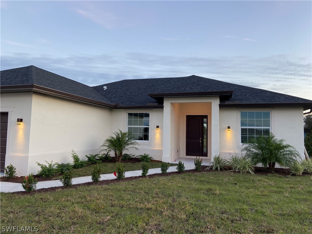5029 Bristo Street Lehigh Acres, FL 33971 - Photo 2 of 14 a front view of a house with a garden