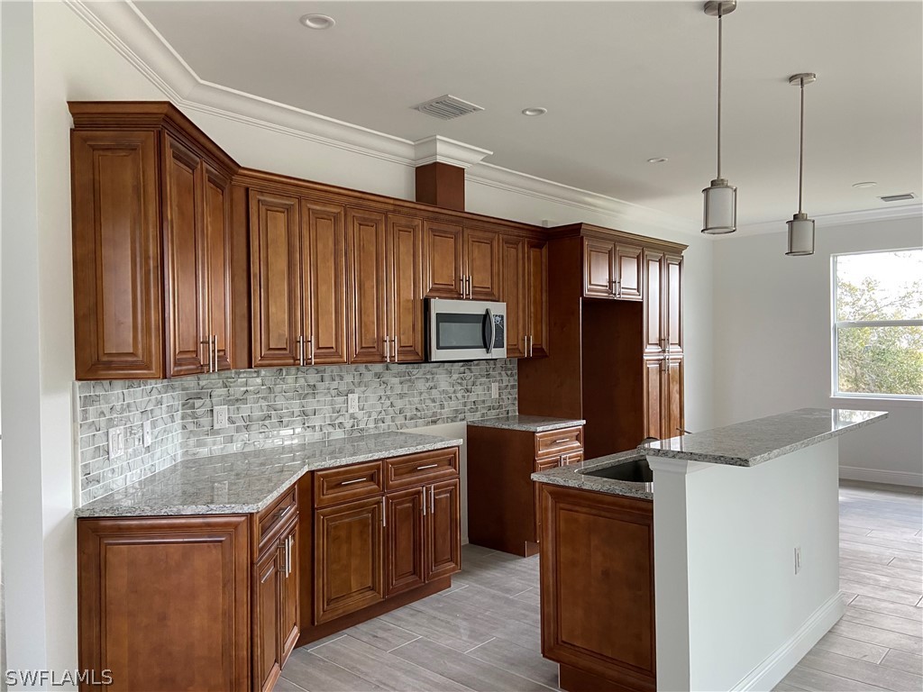 5029 Bristo Street Lehigh Acres, FL 33971 - Photo 5 of 14 a kitchen with wooden cabinets and a refrigerator
