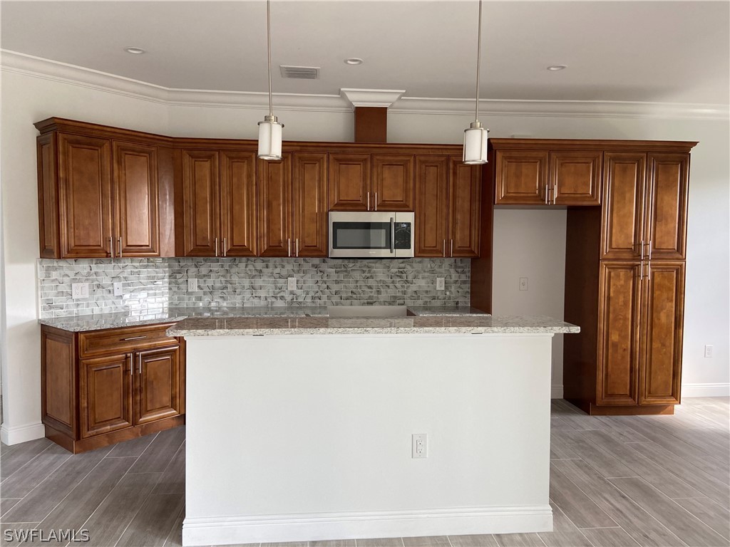 5029 Bristo Street Lehigh Acres, FL 33971 - Photo 6 of 14 a kitchen with stainless steel appliances granite countertop wooden cabinets a refrigerator and a sink