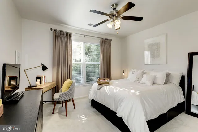 a bedroom with a bed a chair and a chandelier