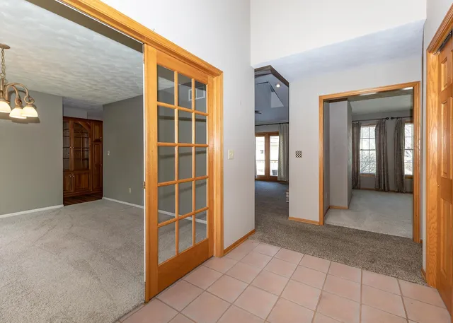 an empty room with windows and chandelier