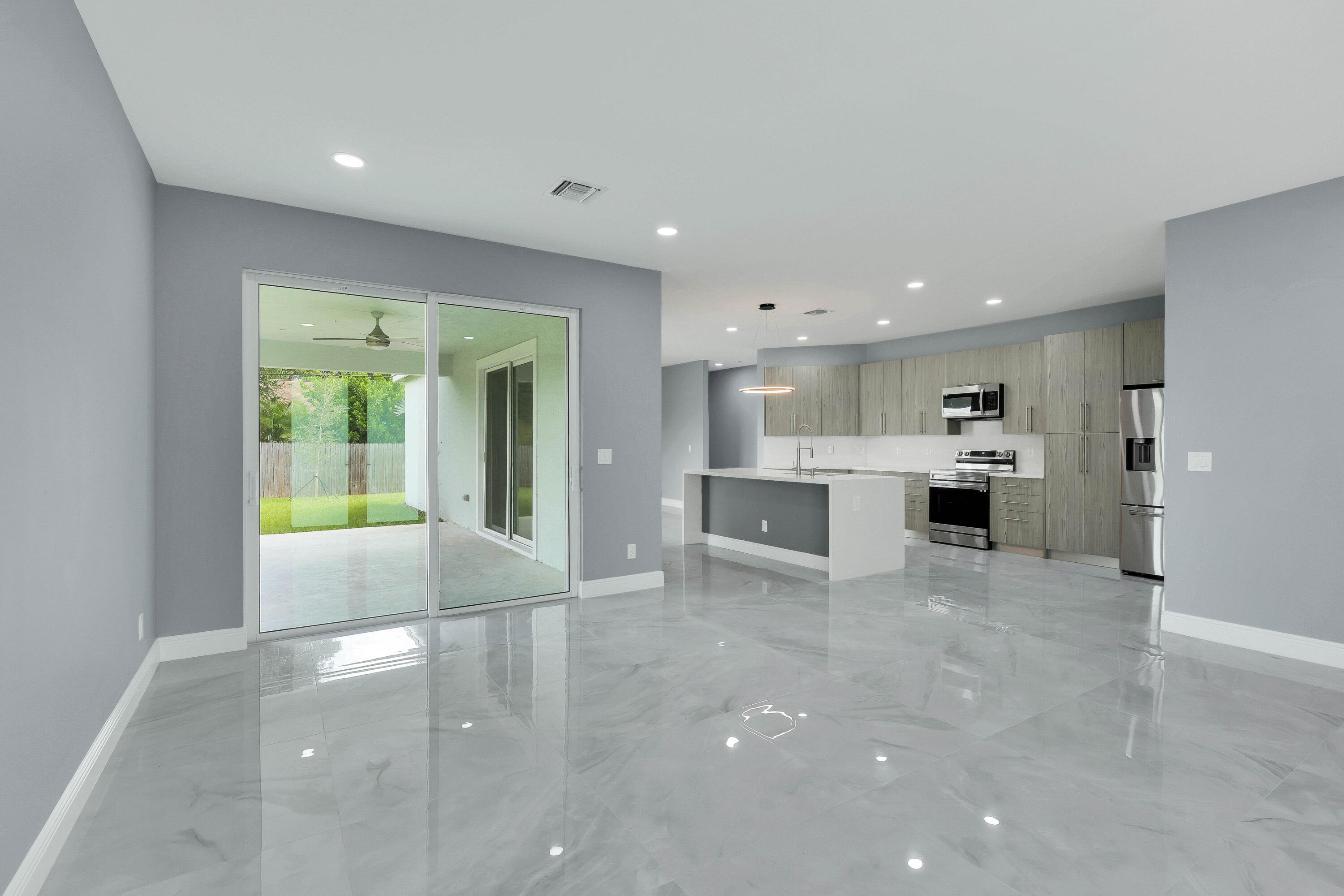 1749 Southwest California Boulevard Port St. Lucie, FL 34953 - Photo 4 of 33 a view of a kitchen with kitchen island a window a counter space and stainless steel appliances