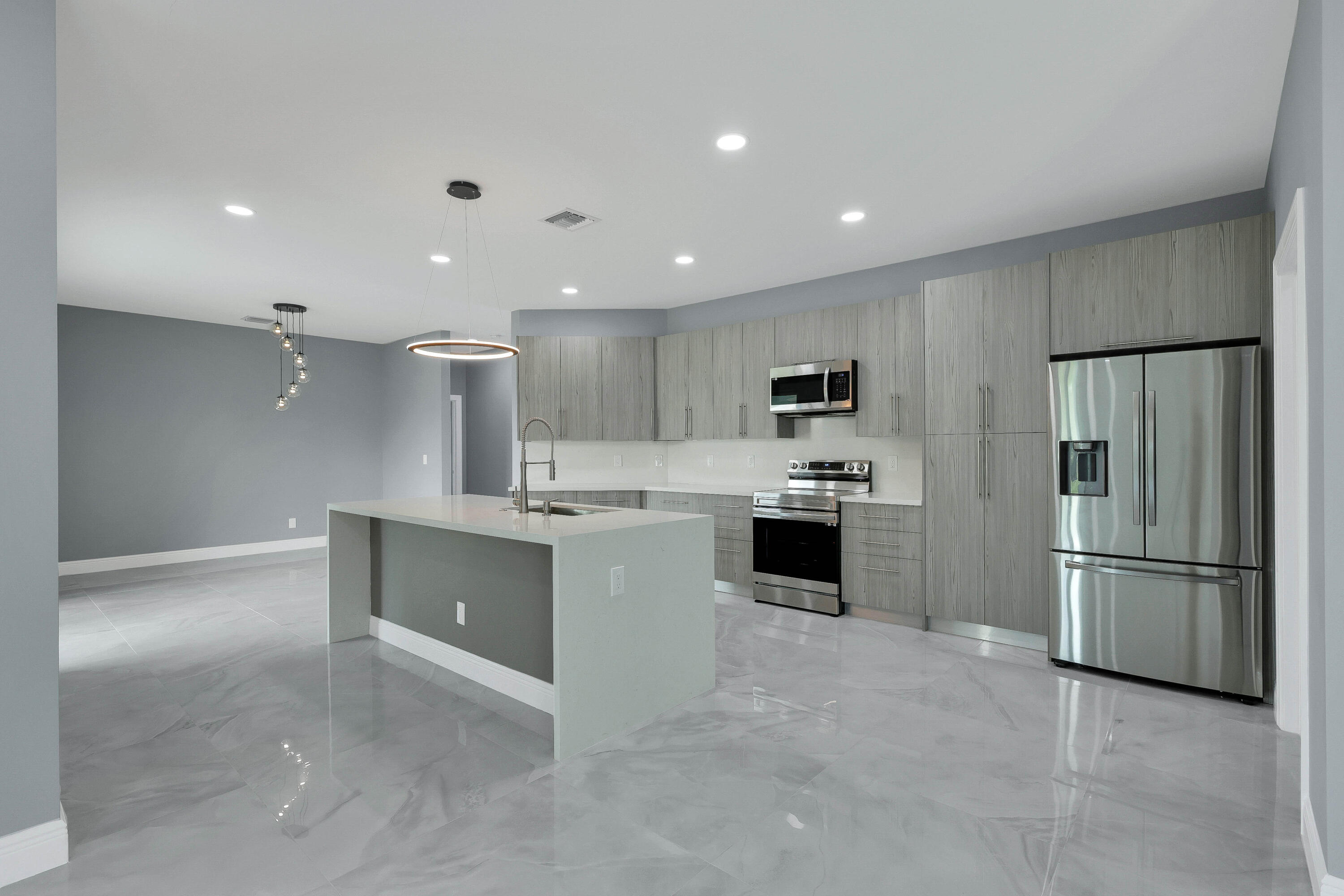 1749 Southwest California Boulevard Port St. Lucie, FL 34953 - Photo 5 of 33 a large kitchen with a refrigerator and a stove top oven