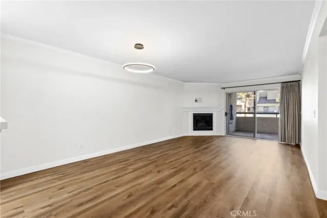 a view of empty room with wooden floor and fireplace