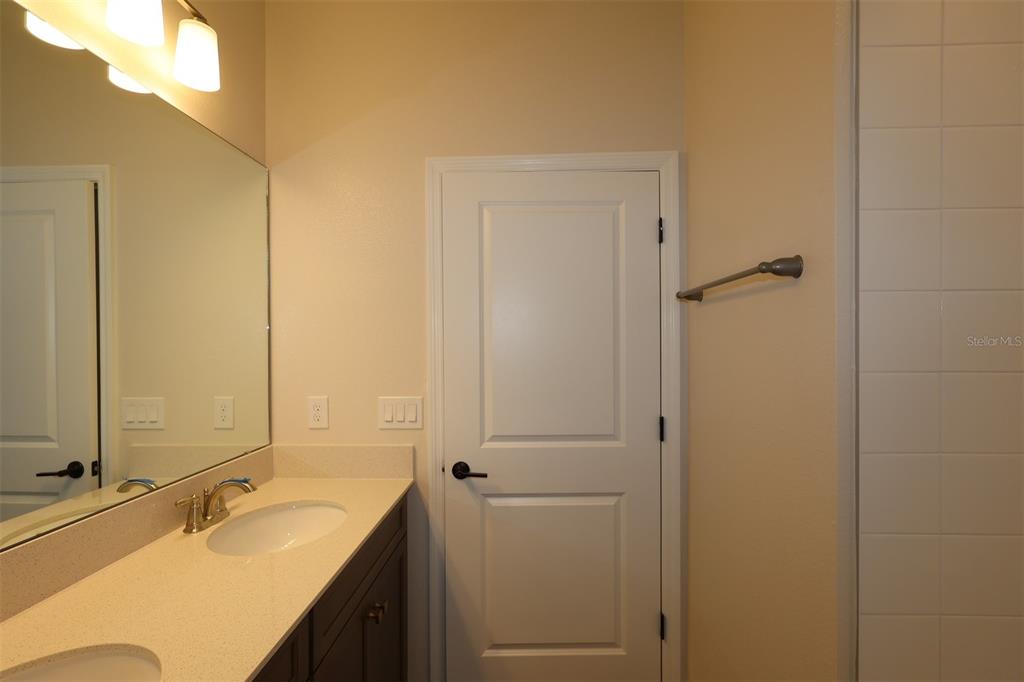 5303 High Line Drive St. Cloud, FL 34771 - Photo 17 of 22 a bathroom with a double vanity sink and mirror