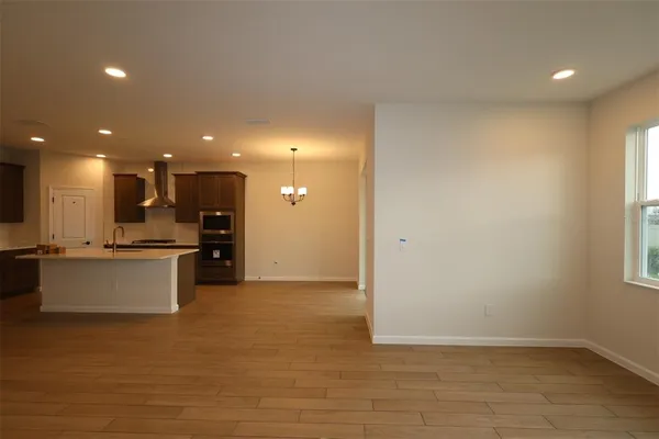 a view of kitchen with kitchen island stainless steel appliances wooden floor and window