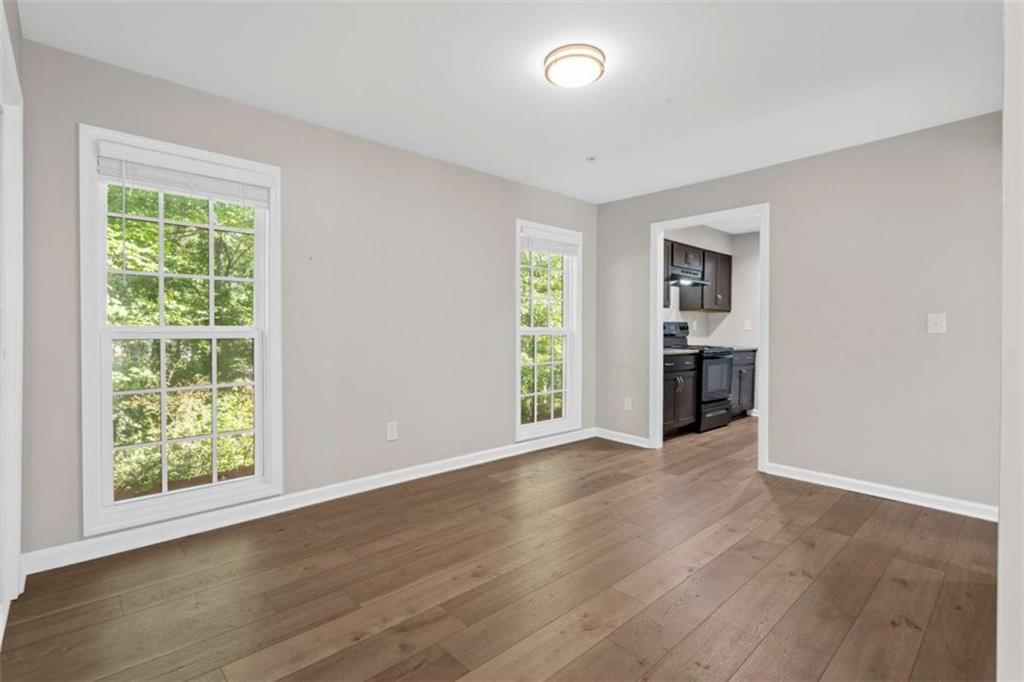 1166 Booth Road, Unit 407 Marietta, GA 30008 - Photo 4 of 18 an empty room with wooden floor and a window